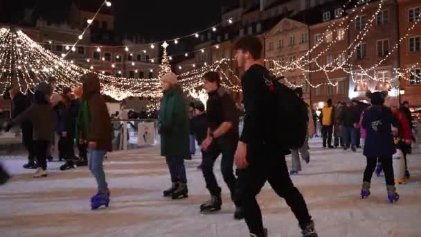 ポーランドのワルシャワの旧市街の真ん中で 幸せな人々のアイススケート クリスマスマーケットの美しいクリスマスの装飾ライト — ストック動画