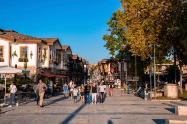 Yana, Hindi. 10 Ekim 2022. İnsanlar caddelerde yürüyorlar. Şehirdeki dükkanların ve binaların arasında. Arka planda açık mavi gökyüzü olan güneşli bir günde.