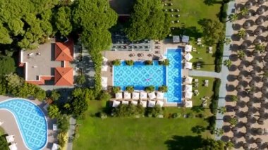 Lüks tropik otel tatil köyü. Açık hava turizmi. Yüzme havuzu, plaj sandalyeleri ve palmiye ağaçları olan lüks bir tatil köyü. Yaz adası seyahati ve cennet tatili