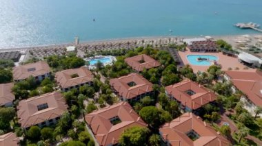 Lüks tropik otel tatil köyü. Açık hava turizmi. Yüzme havuzu, plaj sandalyeleri ve palmiye ağaçları olan lüks bir tatil köyü. Yaz adası seyahati ve cennet tatili