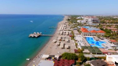 Lüks tropik otel tatil köyü. Açık hava turizmi. Yüzme havuzu, plaj sandalyeleri ve palmiye ağaçları olan lüks bir tatil köyü. Yaz adası seyahati ve cennet tatili