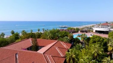 Lüks tropik otel tatil köyü. Açık hava turizmi. Yüzme havuzu, plaj sandalyeleri ve palmiye ağaçları olan lüks bir tatil köyü. Yaz adası seyahati ve cennet tatili