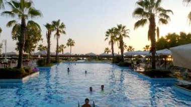 Lüks tropik otel tatil köyü. Açık hava turizmi. Yüzme havuzu, plaj sandalyeleri ve palmiye ağaçları olan lüks bir tatil köyü. Yaz adası seyahati ve cennet tatili