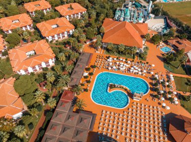 Lüks tropik otel tatil köyü. Açık hava turizmi. Yüzme havuzu, plaj sandalyeleri ve palmiye ağaçları olan lüks bir tatil köyü. Yaz adası seyahati ve cennet tatili