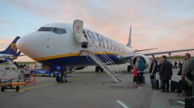 Harika bir havada Stansted havaalanında Ryanair uçağına binmek için kuyrukta bekleyenler..