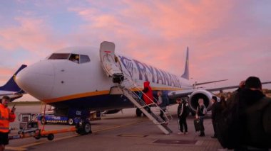 Harika bir havada Stansted havaalanında Ryanair uçağına binmek için kuyrukta bekleyenler..