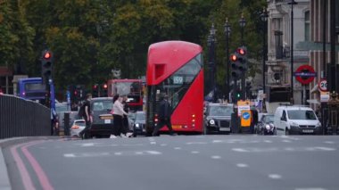Londra 'daki Big Ben saat kulesinin yakınındaki Westminster Köprüsü trafiğinin görüntüsü. İkonik siyah taksiler ve kırmızı çift katlı otobüsler köprüden geçer. Londra 'nın Sembolü.