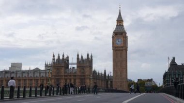 Londra 'daki Big Ben saat kulesinin yakınındaki Westminster Köprüsü trafiğinin görüntüsü. İkonik siyah taksiler ve kırmızı çift katlı otobüsler köprüden geçer. Londra 'nın Sembolü.