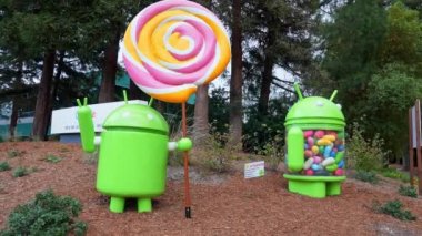 Statue of Android Lollipop and Jelly Bean with sign board in front of trees at campus of Google office