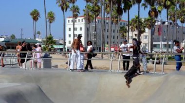 Skateboarder at the skatepark in Venice Beach, CA. People skating at the beach. This 16,000 sq. foot skatepark is one of the only in the world located on a beach.