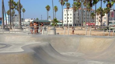 Skateboarder at the skatepark in Venice Beach, CA. People skating at the beach. This 16,000 sq. foot skatepark is one of the only in the world located on a beach.