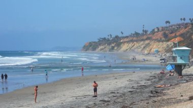 Kumsaldaki cankurtaran kulesi ve güneşli bir günde San Diego 'da açık mavi gökyüzü ile denize düşen dalgaların manzarası.