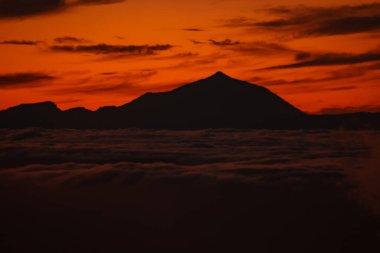 Tenerife 'deki Teide volkanı ulusal parkının bulutlarının üzerinde muhteşem bir günbatımı. Gran Canaria Adası 'nın tepesinden gün batımı. Pico de las Nieves.