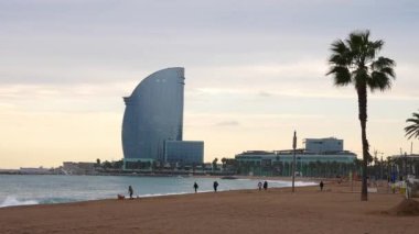 View of the Barceloneta beach with luxury hotel W Barcelona by the sea shore. Beautiful luxury hotel in Barcelona.