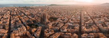 Aerial view of Barcelona City Skyline and Sagrada Familia Cathedral at sunset. Eixample residential famous urban grid. Cityscape with typical urban octagon blocks