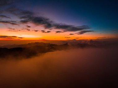 Magical sunset above the clouds with Teide volcano on the horizon. Sunset cinematic view from the top of Gran Canaria Island Pico de las Nieves point.