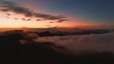 Magical sunset above the clouds with Teide volcano on the horizon. Sunset cinematic view from the top of Gran Canaria Island Pico de las Nieves point.