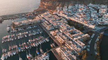 Puerto de Mogan fishing town aerial view at sunset. Traditional colorful buildings with many fishing boats at Gran Canaria, Canary Islands, Spain