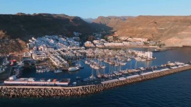 Puerto de Mogan fishing town aerial view at sunset. Traditional colorful buildings with many fishing boats at Gran Canaria, Canary Islands, Spain
