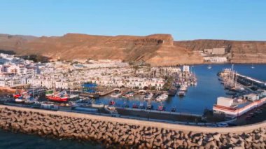Puerto de Mogan fishing town aerial view at sunset. Traditional colorful buildings with many fishing boats at Gran Canaria, Canary Islands, Spain