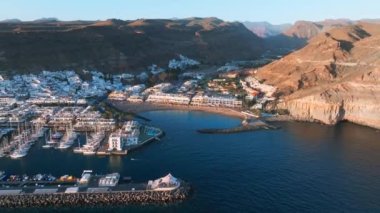 Puerto de Mogan fishing town aerial view at sunset. Traditional colorful buildings with many fishing boats at Gran Canaria, Canary Islands, Spain