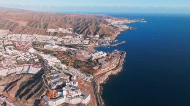 Gran Canaria adasının güzel hava manzarası. Atlantik Okyanusu kıyısındaki sihirli uçurumlar, küçük binalar ve doğal manzara. 