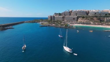 Aerial view of yacht in deep blue sea by the Gran Canaria coastline. Amazing view of luxury yachts sailing in open sea on a calm day.