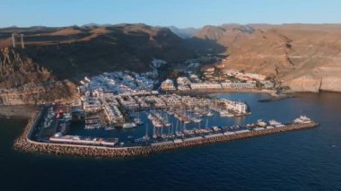 Puerto de Mogan balıkçı kasabası hava manzaralı gün batımında. Gran Canaria, Kanarya Adaları, İspanya 'da birçok balıkçı teknesi olan geleneksel renkli binalar