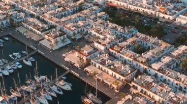 Puerto de Mogan balıkçı kasabası hava manzaralı gün batımında. Gran Canaria, Kanarya Adaları, İspanya 'da birçok balıkçı teknesi olan geleneksel renkli binalar