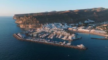 Puerto de Mogan balıkçı kasabası hava manzaralı gün batımında. Gran Canaria, Kanarya Adaları, İspanya 'da birçok balıkçı teknesi olan geleneksel renkli binalar