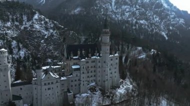 Bir kış günü Neuschwanstein Kalesi 'nin veya Schloss Neuschwanstein' in hava manzarası. Etrafı karla kaplı dağlar ve ağaçlarla çevrili..