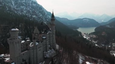 Bir kış günü Neuschwanstein Kalesi 'nin veya Schloss Neuschwanstein' in hava manzarası. Etrafı karla kaplı dağlar ve ağaçlarla çevrili..