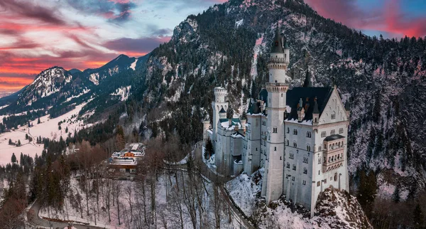 Bir kış günü Neuschwanstein Kalesi 'nin veya Schloss Neuschwanstein' in hava manzarası. Etrafı karla kaplı dağlar ve ağaçlarla çevrili..