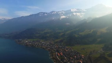 Göl kenarındaki ormanlı kayalık uçurumların havadan görünüşü. Dramatik ve resimli bir sahne. İsviçre Alpleri 'nde Bachalpsee, Grindelwald Vadisi, Bernese Oberland, Avrupa. Güzellik dünyası.