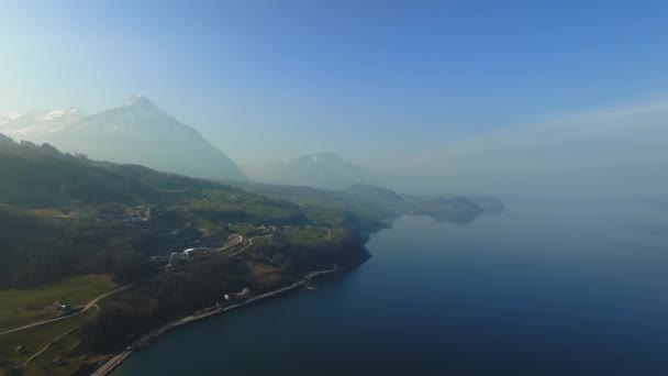 Vista Aérea Los Acantilados Rocosos Nevados Con Bosque Junto Lago — Vídeo de stock
