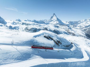 Zermatt, İsviçre Gonergratbahn treni Gornergrat istasyonuna doğru koşuyor ve Matterhorn 'u net bir şekilde gören ünlü turistik bir yerde gözlemevi var..