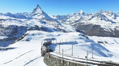 Zermatt, İsviçre Gonergratbahn treni Gornergrat istasyonuna doğru koşuyor ve Matterhorn 'u net bir şekilde gören ünlü turistik bir yerde gözlemevi var..