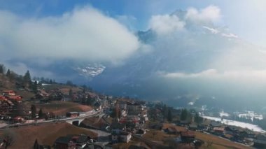 İsviçre 'nin Grindelwald, İsviçre köyü manzarası İsviçre Alpleri yakınlarındaki panorama manzarası, yeşil tarlalarda ahşap kiremitler ve arka planda yüksek zirveler, Bernese Oberland, Avrupa.