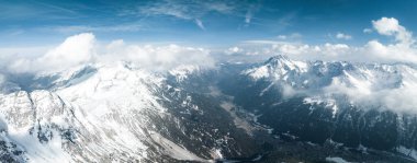 Tepeleri kar ve bulutlarla kaplı dağlık bir arazi. Ünlü St. Anton am Arlberg kayak merkezindeki dağların zirvelerini kaplayan sihirli bulutlar.