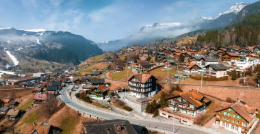 İsviçre 'nin Grindelwald, İsviçre köyü manzarası İsviçre Alpleri yakınlarındaki panorama manzarası, yeşil tarlalarda ahşap kiremitler ve arka planda yüksek zirveler, Bernese Oberland, Avrupa.