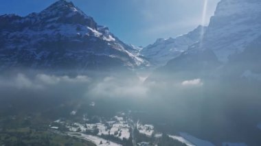 İsviçre 'nin Grindelwald, İsviçre köyü manzarası İsviçre Alpleri yakınlarındaki panorama manzarası, yeşil tarlalarda ahşap kiremitler ve arka planda yüksek zirveler, Bernese Oberland, Avrupa.