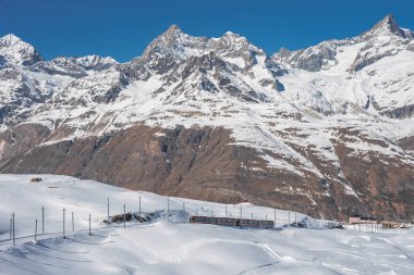 Gonergratbahn treni Gornergrat İstasyonu ve Stellarium Gözlemevi 'ne doğru koşuyor. Matterhorn' u net görebilen ünlü turistik bir yer. Buzul Ekspresi Treni.
