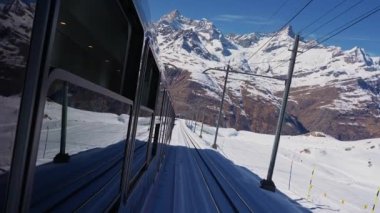 İsviçre 'nin Valais Alplerindeki Zermatt kayak merkezindeki ikonik çarklı Gornergrat trenine binmek güneşli bir kış gününde İsviçre' de trene binmek.