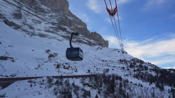 山頂と斜面の景色を望むスキーチェアリフト 青空と明るい太陽と雪の後の美しいスキー場 スキーヤーやスノーボーダーを運ぶスキーキャビン — ストック動画