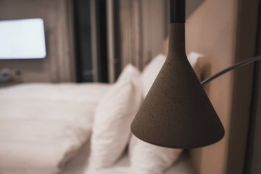 Lüks otelin aydınlık boş odasında lamba yatak, lüks seyahat konsepti