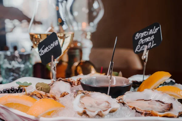 stock image Fresh Oysters close up on a plate, served table with oysters, lemon and ice. Healthy sea food. Fresh Oyster dinner with sparkling wine in a restaurant. Gourmet food