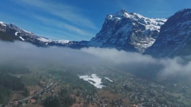 İsviçre 'nin Grindelwald, İsviçre köyü manzarası İsviçre Alpleri yakınlarındaki panorama manzarası, yeşil tarlalarda ahşap kiremitler ve arka planda yüksek zirveler, Bernese Oberland, Avrupa.