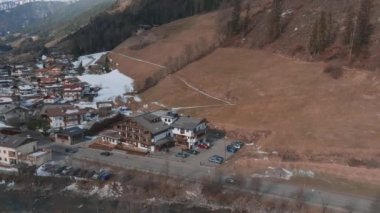 Bulutlu bir kış gününde, İtalya 'nın Tyrol kentinde, köyün ortasında çiçeklerle süslenmiş tipik ahşap bir dağ evi. Hava görünümü.