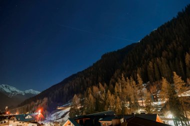 Grindelwald 'daki evler ve Bernese dağ yamacında yetişen güzel çam ağaçlarının manzarası ve geceleri mavi gökyüzü.