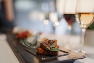 Lüks oteldeki modern restoranda tabakta servis edilen taze pişmiş et ve şarap bardakları, turistler için lüks seyahat kavramı.